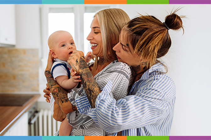 Young Same Sex Couple Adoringly Smile At Their Baby Boy